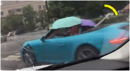 敞（chǎng）篷跑車打傘前行